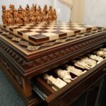 Handcrafted chess set. The board is made of ash in a dark brown color with carvings and 2 drawers for storage