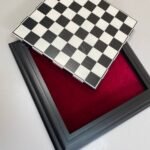A wooden chess board with a removable game board and storage space for the pieces