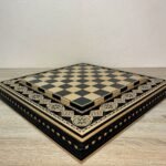 Handmade ash chess board decorated with carvings and beaded inlay