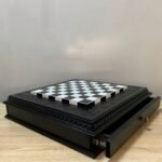 An elegant chess board with two storage drawers. The black and white design, velvet lining and carved details