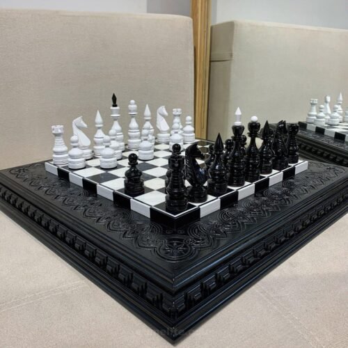 A classic chess set with a contrasting black and white ash board with carved edges