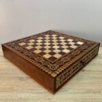 A luxurious handcrafted chess board with carvings, bead inlay and two drawers on a velvet lining