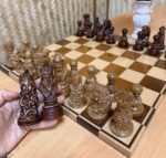 A classic, handcrafted chess set: an ash board with an ombre, mirror-like finish, and maple pieces in a Slavic ethnic style
