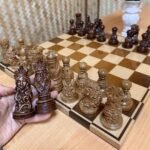 A classic, handcrafted chess set: an ash board with an ombre, mirror-like finish, and maple pieces in a Slavic ethnic style